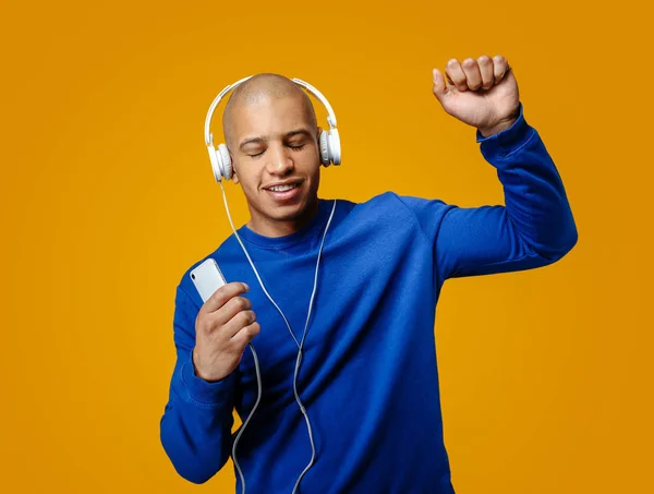 Όμορφος Αφροαμερικανός άνθρωπος ακούγοντας μουσική στο φόντο του χρώματος — Φωτογραφία Αρχείου