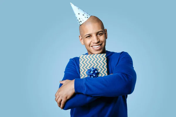 African-American man with Birthday gift on color background — Stock Photo, Image