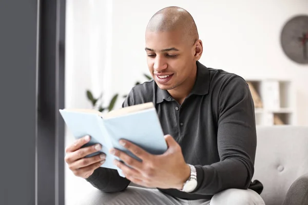 African-American man reading book at home — Stock Photo, Image