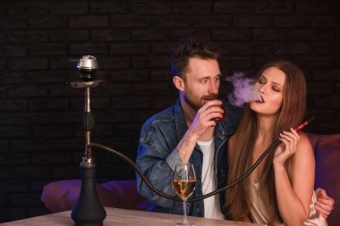 Kafede nargile içen genç bir çift.