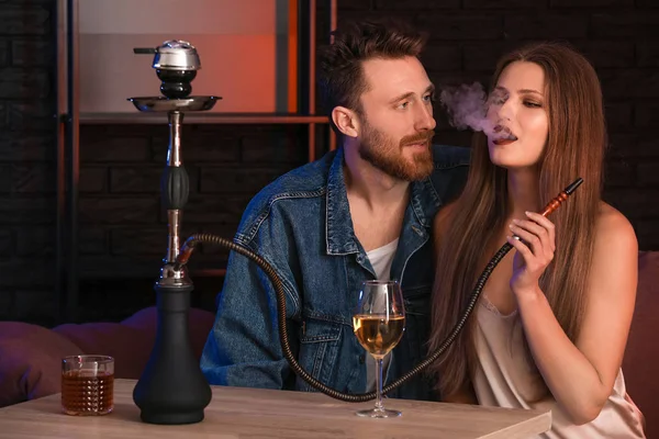 Young couple smoking hookah in cafe — 스톡 사진