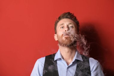 Genç adam arka planda sigara içiyor.