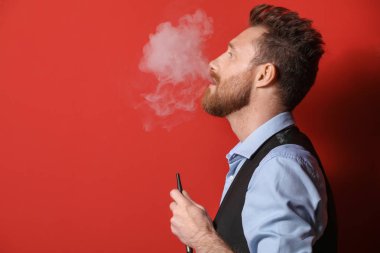 Genç adam arka planda nargile içiyor.