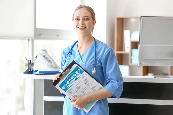 Young medical assistant with results of laboratory tests in clinic — Stock Photo, Image