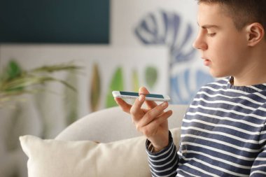 Genç çocuk odasında cep telefonu ile. Modern teknoloji ve akıllı ev otomasyon