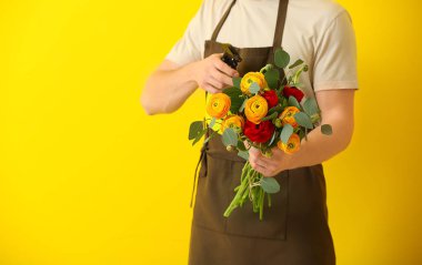 Renkli arka planda yakışıklı çiçekçi