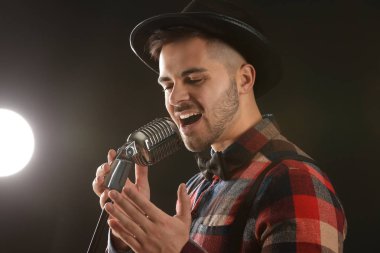 Sahnede mikrofon ile yakışıklı erkek şarkıcı