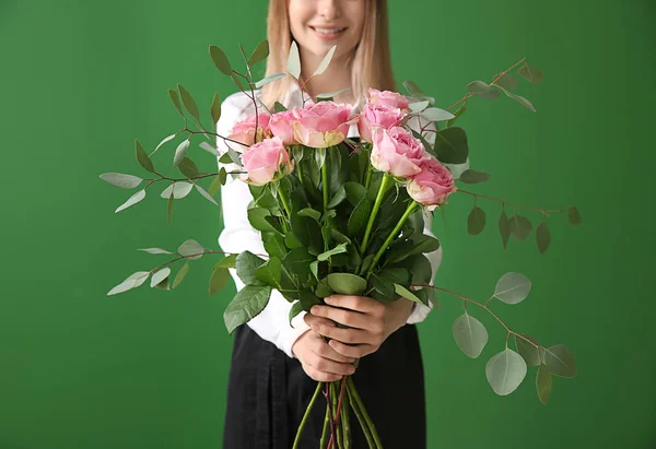 Jeune fleuriste féminine avec bouquet sur fond de couleur — Photo