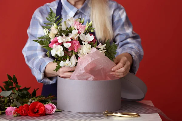 Fleuriste avec beau bouquet et coffret cadeau à table, gros plan — Photo