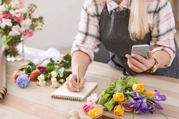 Florist taking order by phone in shop — Stock Photo, Image