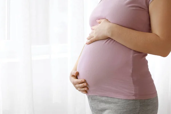 Молодая беременная женщина дома — стоковое фото