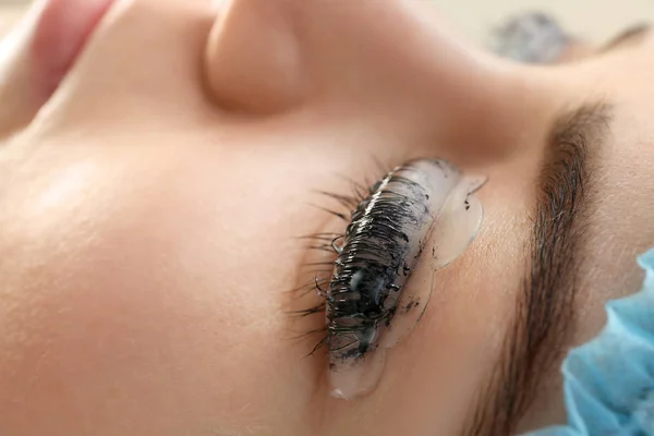 Young woman undergoing procedure of eyelashes dyeing and lamination in beauty salon, closeup — 스톡 사진