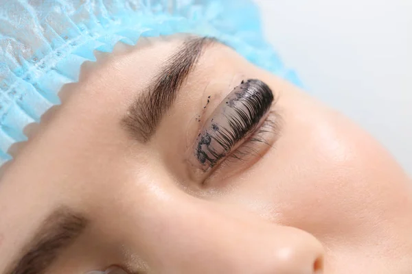 Young woman undergoing procedure of eyelashes dyeing and lamination in beauty salon, closeup — Stock Photo, Image