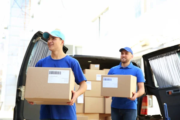 Delivery men carrying boxes to client — Stock Photo, Image