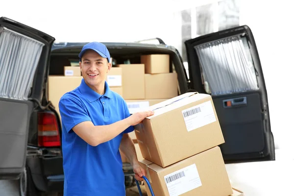 Handsome delivery man near car with parcels outdoors — Stock Photo, Image