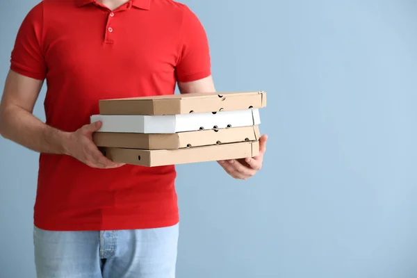 Entrega homem com caixas de pizza no fundo de cor — Fotografia de Stock