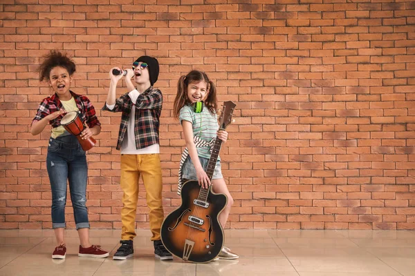 Band der kleinen Musiker gegen Backsteinmauer — Stockfoto