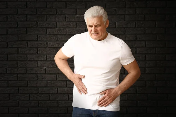 Mature man with urologic disease on dark background — Stock Photo, Image