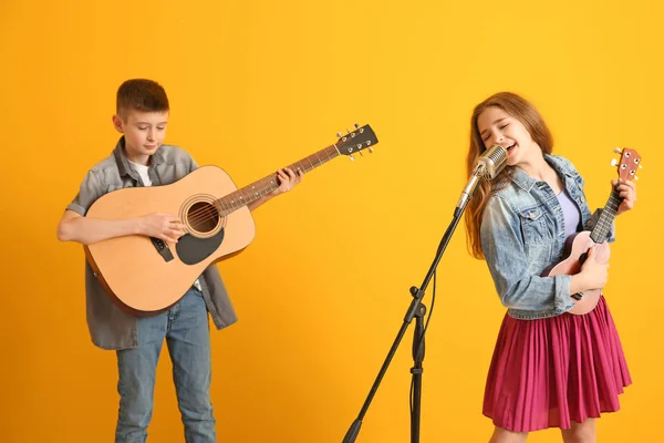 Юные музыканты играют на цветном фоне — стоковое фото