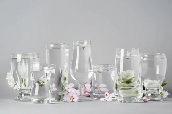 Окуляри з водою і квітами на столі — стокове фото
