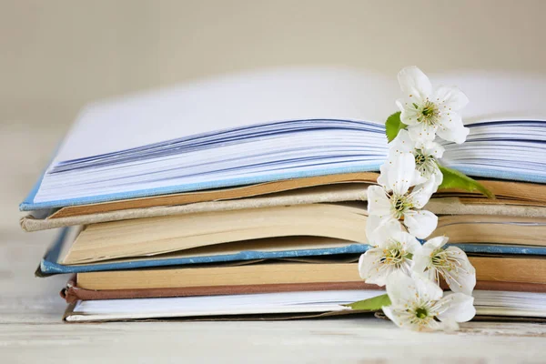 Öppna böcker och vackra blommor på bordet, närbild — Stockfoto