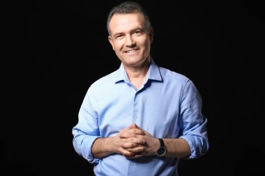 Koyu arka plan üzerinde yakışıklı olgun işadamı