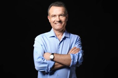 Koyu arka plan üzerinde yakışıklı olgun işadamı