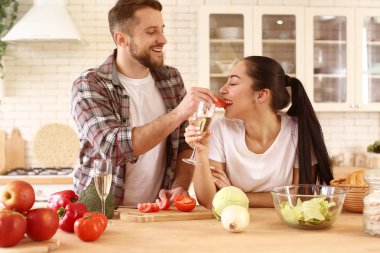Genç ve güzel bir çift mutfakta birlikte yemek pişiriyor.