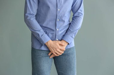 Ürolojik hastalığı olan ve gri arka planda olan adam