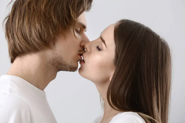 Beijar jovem casal no fundo de luz — Fotografia de Stock