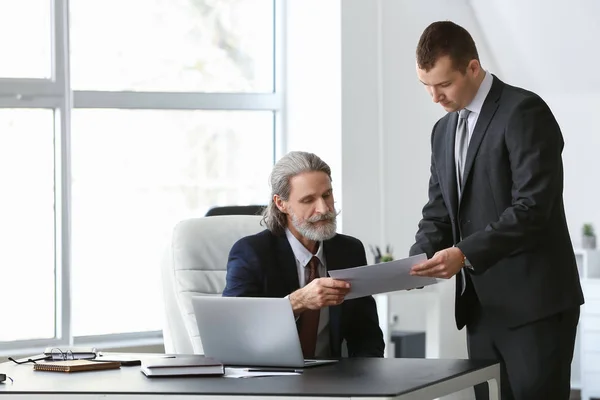 Reifer Geschäftsmann arbeitet mit jungem Amtskollegen zusammen — Stockfoto