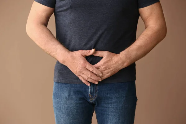 Mann mit urologischer Erkrankung auf farbigem Hintergrund — Stockfoto