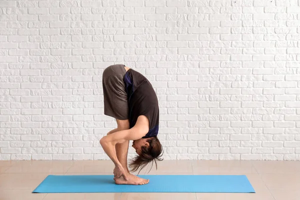 Sporty man practicing yoga indoors — Stock Photo, Image