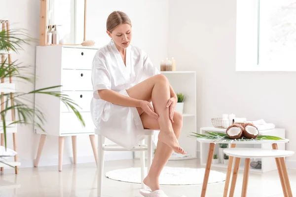 Beautiful young woman applying coconut oil at home — Stock Photo, Image