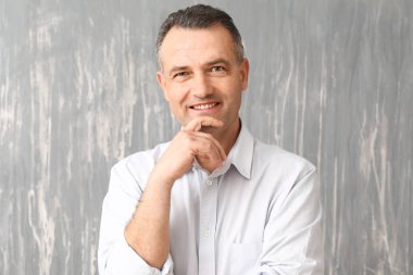 Yakışıklı olgun işadamı gri arka plan üzerinde