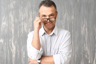 Yakışıklı olgun işadamı gri arka plan üzerinde