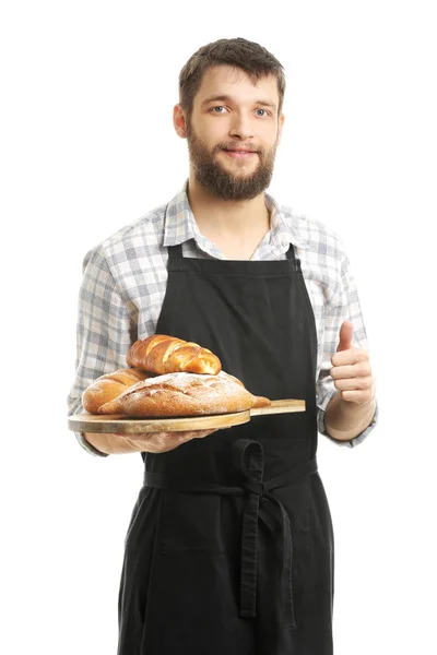 Junger Koch mit frischen Backwaren zeigt Daumen-hoch-Geste auf weißem Hintergrund — Stockfoto