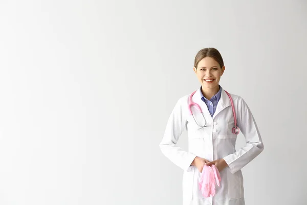 Portrait of young gynecologist on light background — Stock Photo, Image