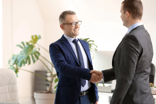 Schöner reifer Geschäftsmann beim Händeschütteln mit Klient im Büro — Stockfoto