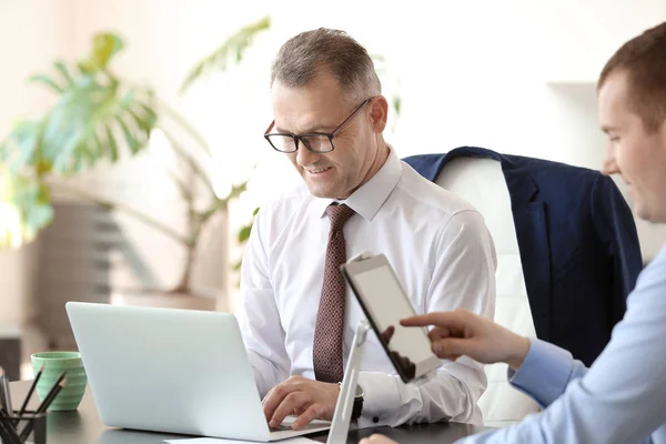 Handsome mature businessman with colleague working in office — Stock Photo, Image