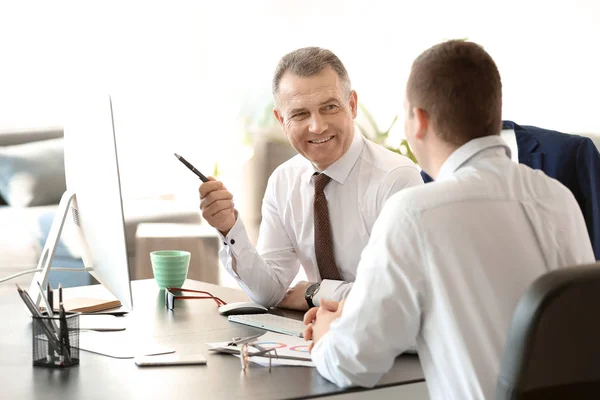 Handsome mature businessman with colleague working in office — Stock Photo, Image