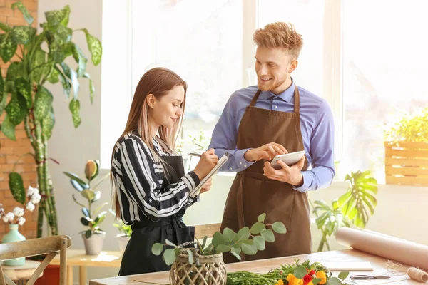 Jonge bloemisten werken in de winkel — Stockfoto