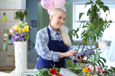 Çiçekçi dükkanında sipariş için ödeme yapan müşteri