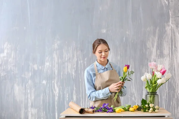 Florista fazendo belo buquê à mesa — Fotografia de Stock