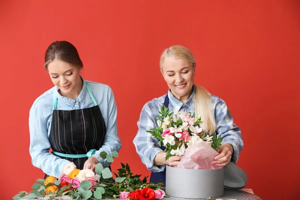 Floristas fazendo belo buquê à mesa — Fotografia de Stock