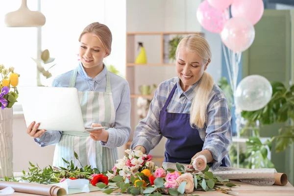 Florists working with laptop in shop — Stock Photo, Image