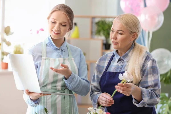 Florists working with laptop in shop — Stock Photo, Image