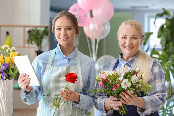 Dükkanda tablet bilgisayar ve buket ile Çiçekçiler — Stok fotoğraf
