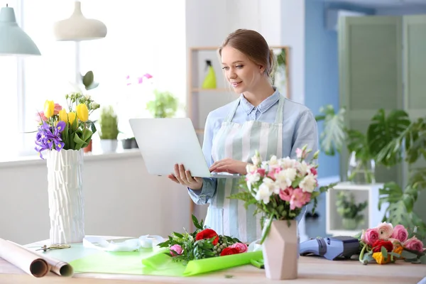 店でラップトップを持つ女性の花屋 — ストック写真