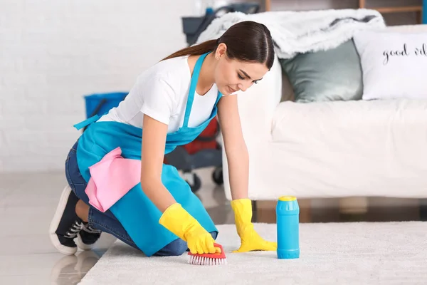 Female janitor cleaning carpet in flat — Stock Photo, Image
